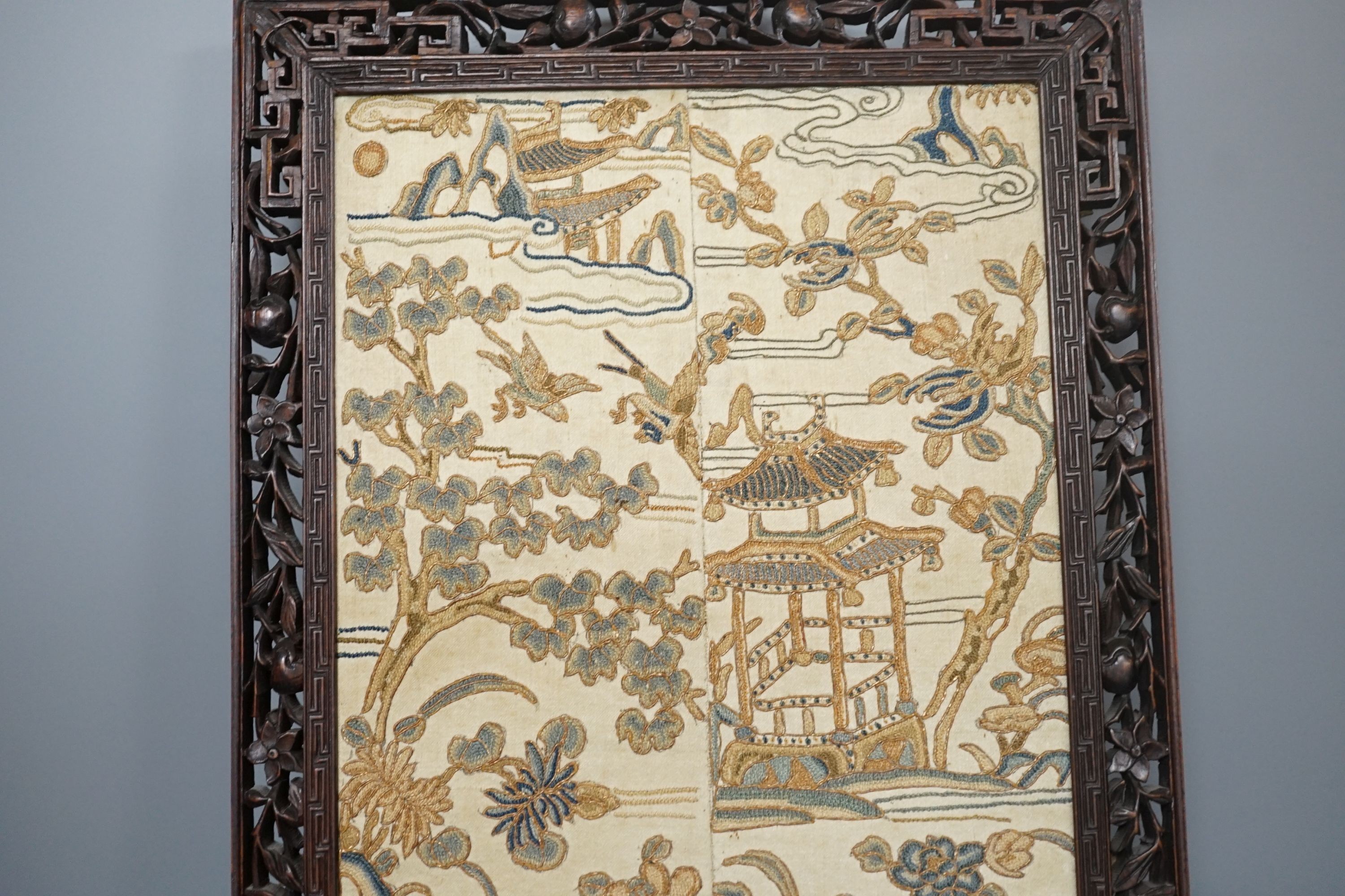 A pair of Chinese silk Beijing knot embroidered sleeve bands in a carved rosewood frame, 22 cms wide x 58.5 cms high, including frame.